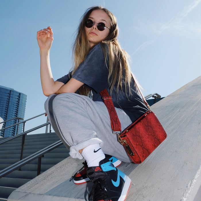 woman in gray t-shirt and gray pants sitting on gray concrete bench during daytime