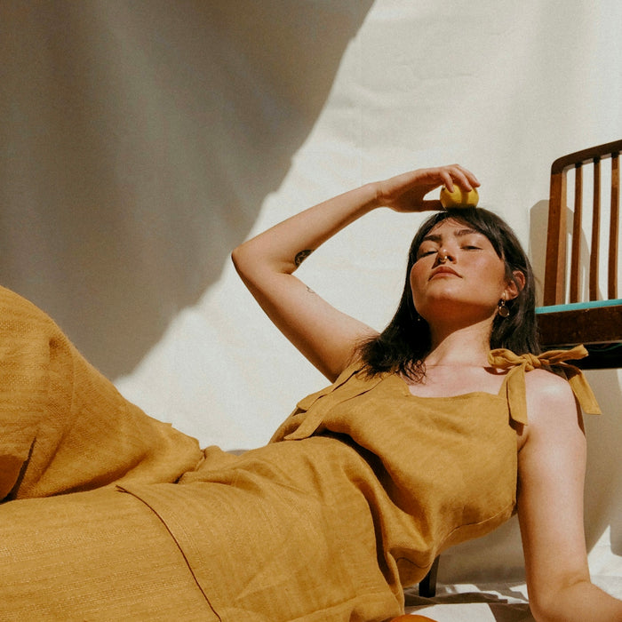 woman in brown sleeveless dress lying on bed