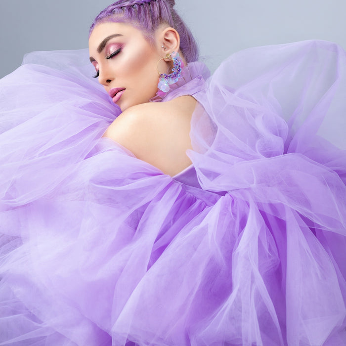 girl in pink dress lying on bed