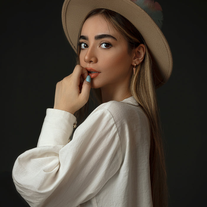 woman in white long sleeve shirt wearing brown hat