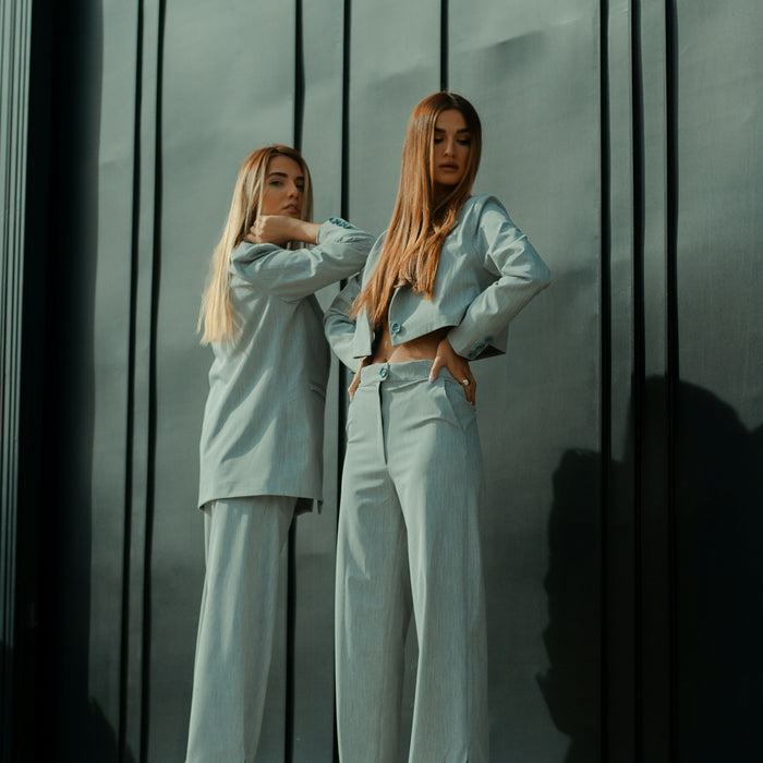 2 women in white long sleeve shirt standing beside glass window