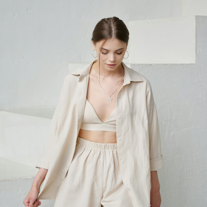 a woman in shorts and a jacket standing in front of a wall