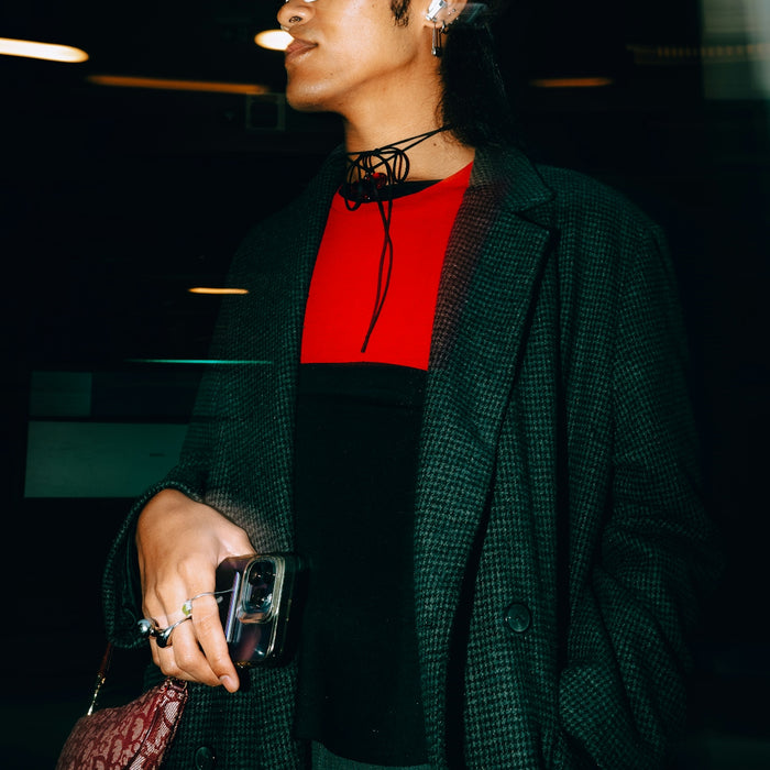 A woman in a black coat and sunglasses holding a purse