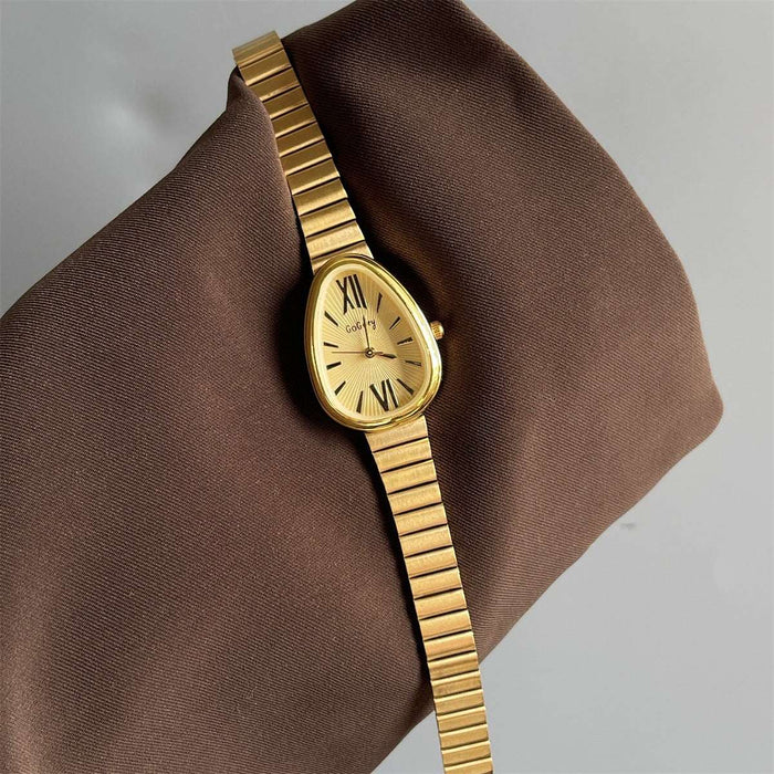 Gold wristwatch on a brown fabric background
