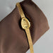 Gold wristwatch on a brown fabric background