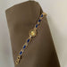 Gold bracelet with blue stones on a brown fabric background