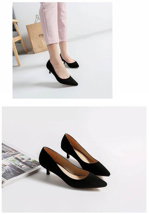 Black high-heeled shoes on a white background with a person wearing them.