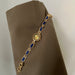 Gold bracelet with blue stones on a brown fabric background