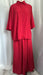 A bright red two-piece clothing set consisting of a short-sleeve button-up shirt and matching wide-leg pants, displayed on a hanger against a white draped fabric backdrop.