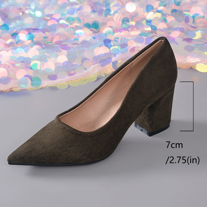 A single pointed-toe high-heeled pump in dark olive-brown suede, shown on a gray surface with a colorful sequined backdrop. A measurement bracket and text indicate a 7 cm heel height.