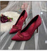 Red high-heeled shoes with embellishments on a decorative background
