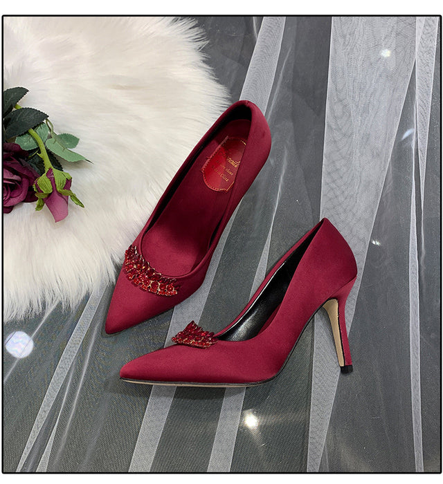 Red high-heeled shoes with embellishments on a decorative background
