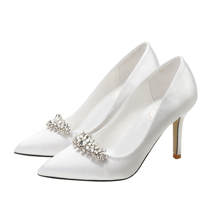 White high-heeled shoes with decorative elements on a white background