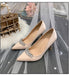 Beige high-heeled shoes with crystal embellishments on a decorative background