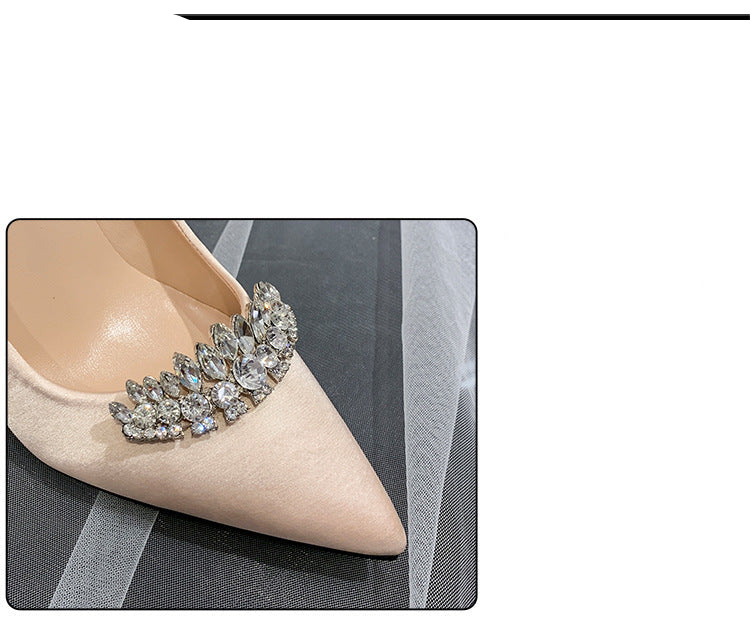 High-heeled shoe with decorative brooch on a black background