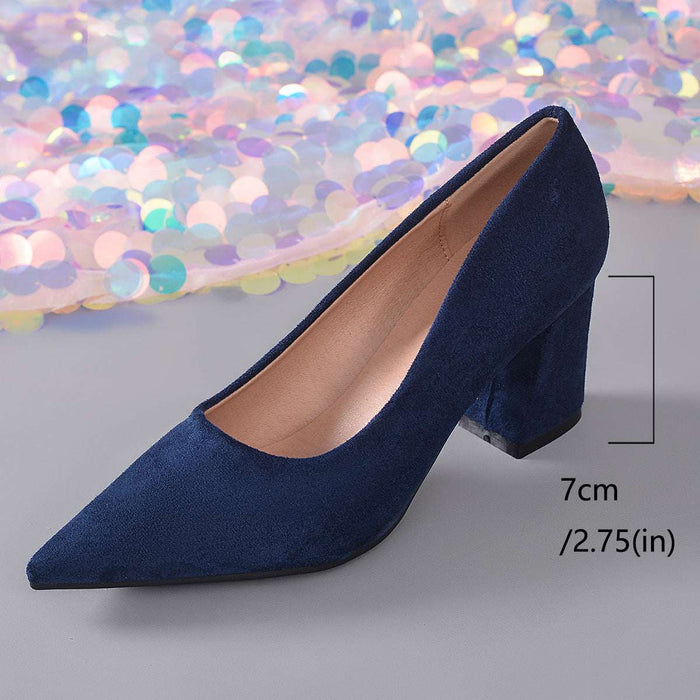 A single navy blue suede pump with a pointed toe and block heel, shown on a gray surface with a decorative iridescent sequin backdrop. A measurement marker indicates the heel height is 7 cm (2.