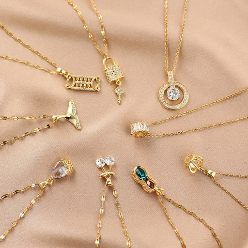Gold necklaces with various pendants on a beige fabric background