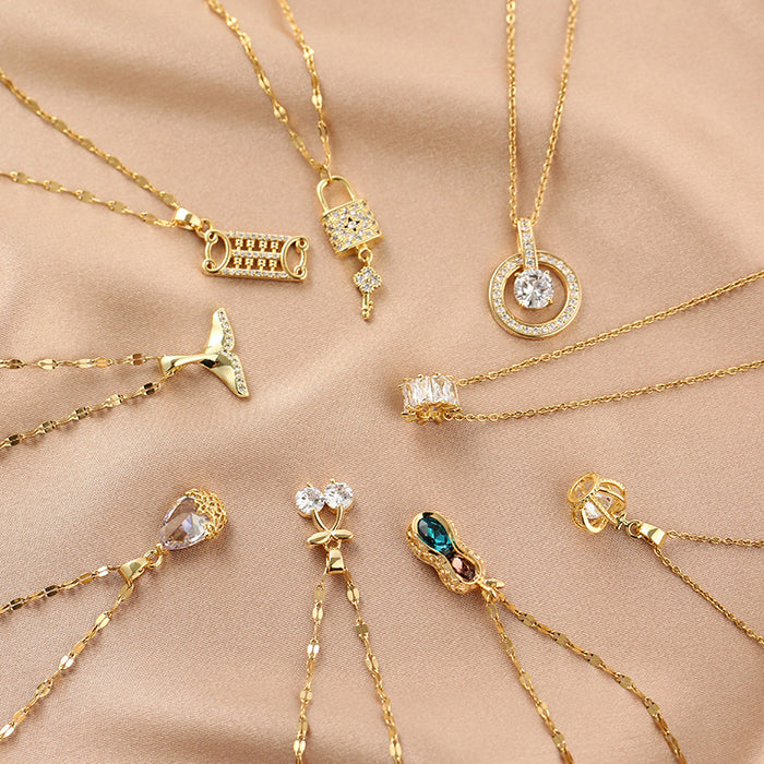 Gold necklaces with various pendants on a beige fabric background