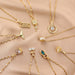 Gold necklaces with various pendants on a beige fabric background