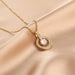 Gold necklace with a diamond pendant on a beige fabric background