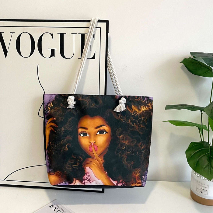 Tote bag with a design of a woman's face on a surface with a 'Vogue' magazine in the background.