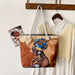Tote bag with a design of a woman with a colorful headscarf hanging on a coat rack.