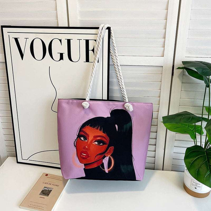 Purple tote bag with a face design in front of a Vogue magazine