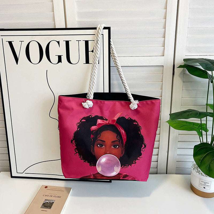 Pink tote bag with a graphic design of a woman blowing a bubble, placed on a surface with a 'Vogue' magazine in the background.