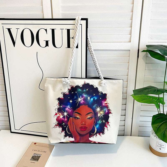 Tote bag with a colorful design of a woman with a starry afro, placed on a surface with a 'Vogue' magazine in the background.