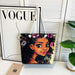 Tote bag with a colorful design of a woman's face on a white surface with a 'Vogue' magazine in the background.