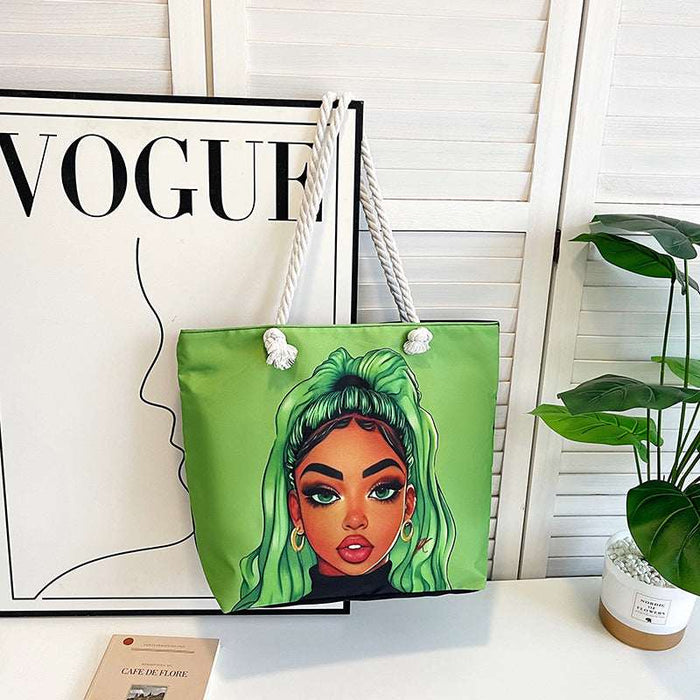 Green tote bag with a colorful face design on a white surface with a 'Vogue' magazine in the background.