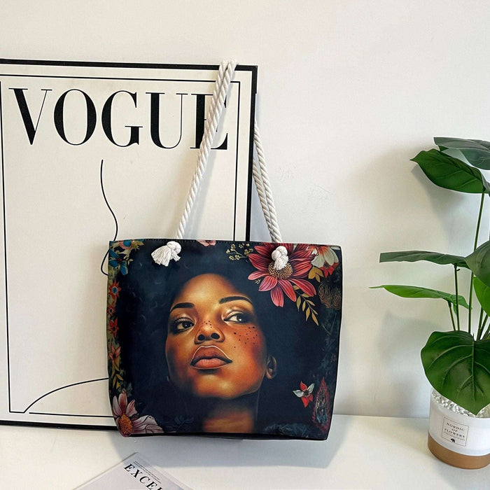 Tote bag with a design of a woman's face and flowers on a surface with a 'Vogue' magazine in the background.