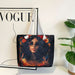 Tote bag with a design of a woman with flowers, placed on a surface next to a 'Vogue' magazine.