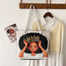 Tote bag with a design of a woman with a crown on a hanger with clothes in the background.