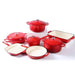 Set of red enameled cookware with white interiors on a white background