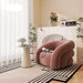 Modern living room with a pink armchair, side table, and decorative elements.