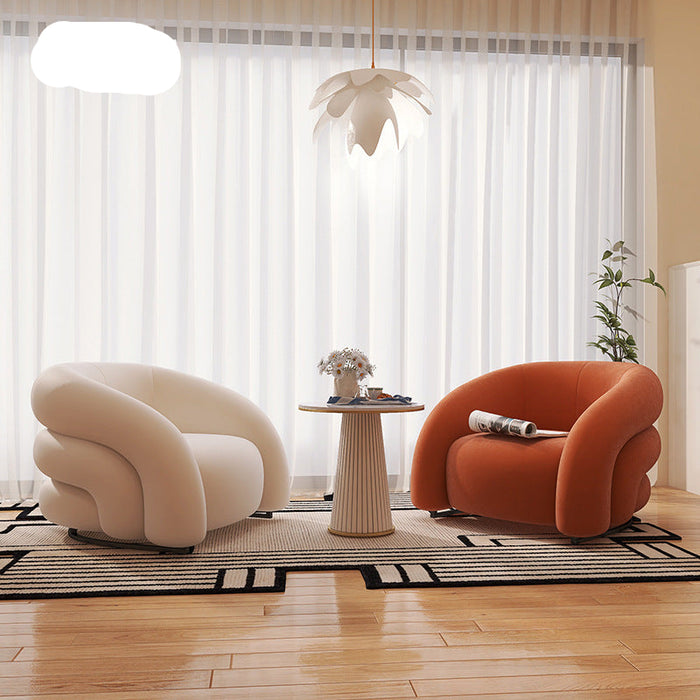 Modern living room with two curved armchairs and a small table.