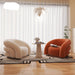 Modern living room with two curved armchairs and a small table.