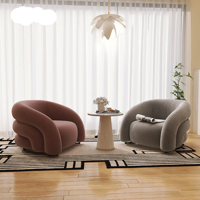 Modern living room with two curved armchairs and a small table.