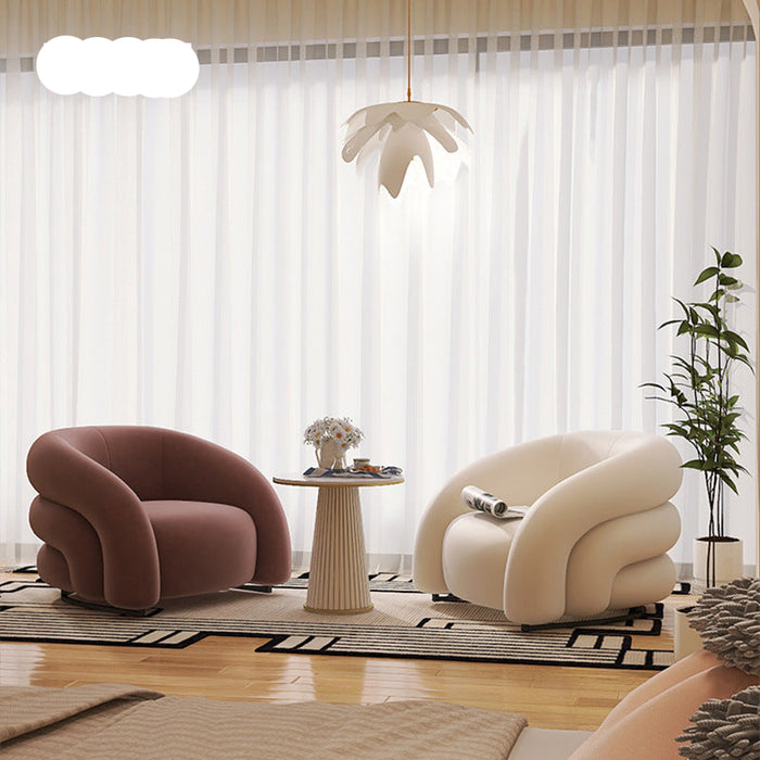 Modern living room with two curved armchairs, a small table, and decorative elements.