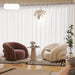 Modern living room with two curved armchairs, a small table, and decorative elements.