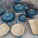 Set of blue cookware with beige interior on a reflective surface