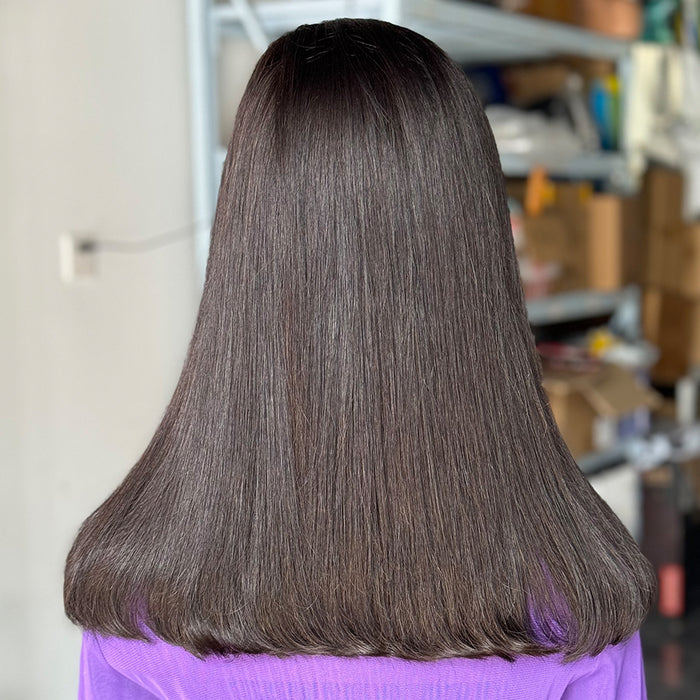 Person with long, straight, dark brown hair in a salon setting.