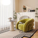 Modern living room with a green armchair, white fireplace, and decorative elements.