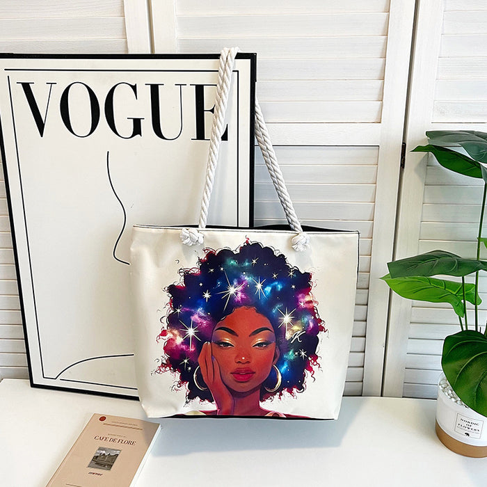 Tote bag with a colorful design of a woman with a starry afro, placed on a surface with a 'Vogue' magazine in the background.