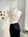 Mannequin wearing a white top and black skirt against a neutral background