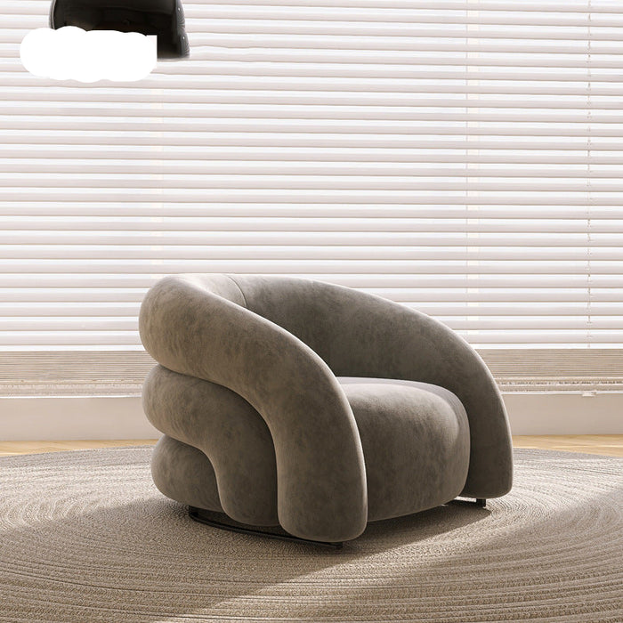 Modern gray armchair in a room with light-colored blinds and carpet.
