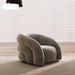 Modern gray armchair in a room with light-colored blinds and carpet.