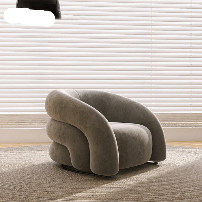 Modern gray armchair in a room with light-colored blinds and carpet.