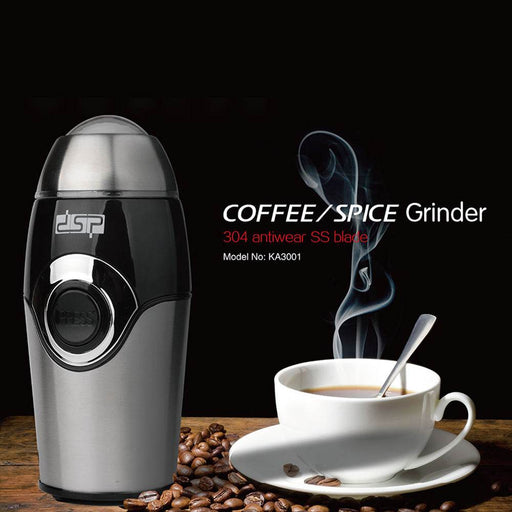 Coffee grinder with a cup of coffee and beans on a dark background